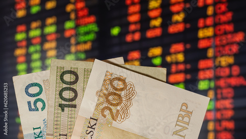 warsaw, poland - 05 07 2023: Polish banknotes PLN, in the background of the stock market on the computer display (selective sharpness)
