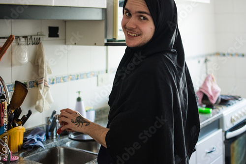 Happy non-binary person washing the dishes