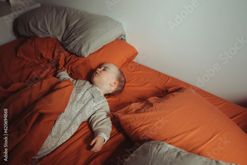 Baby asleep in adults bed photo