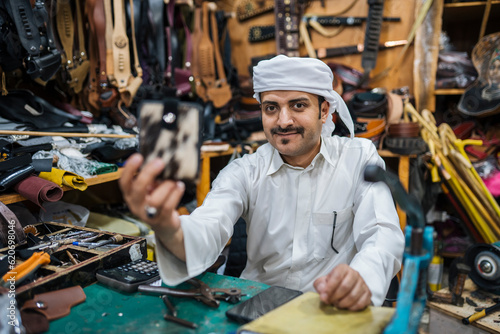 Content craftsman demonstrating handmade wallet in shop photo