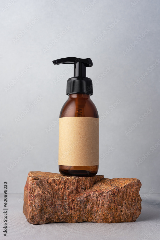 Brown glass bottle standing on stone for cosmetic product mock up