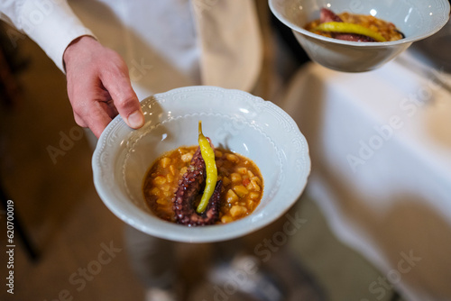 Crop waiter serving dishes with octopus photo