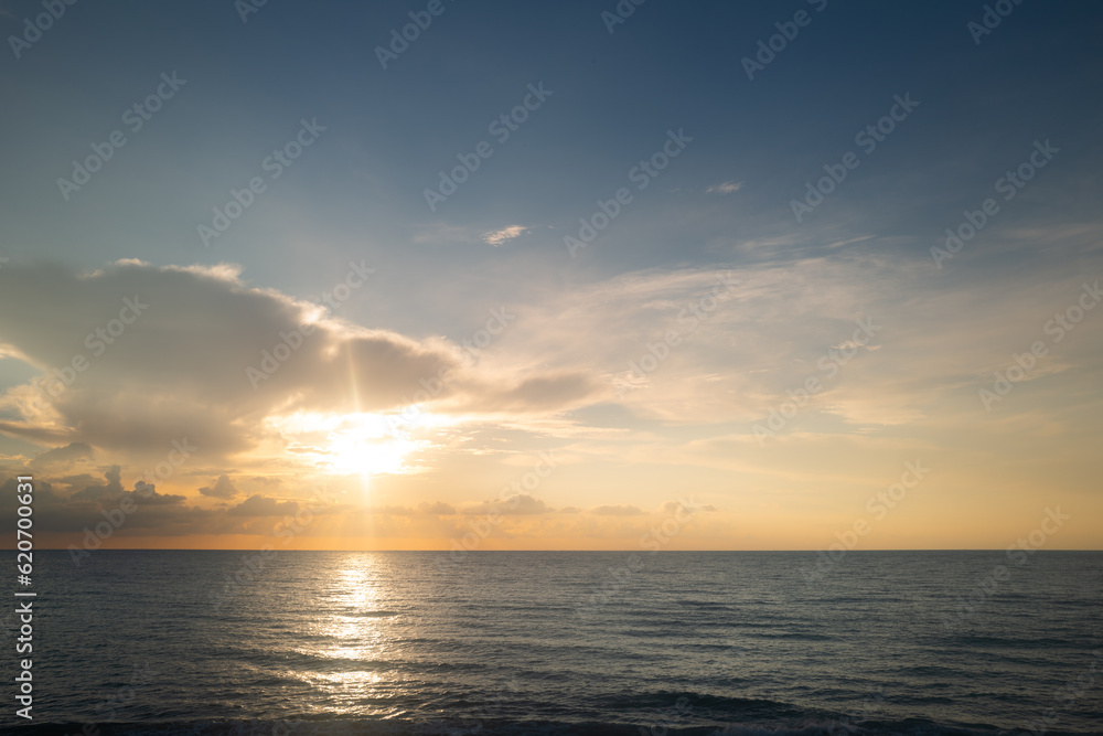Sunset sea landscape. Ocean sunset on sky background with colorful clouds. Colorful beach sunrise with calm waves. Nature sea sky. Sunrise with clouds of different colors against the blue sky and sea.