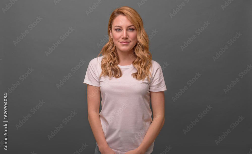 Smiling girl on a grey background, crossed her arms over her chest. Smiling girl on a grey background, crossed her arms over her chest.