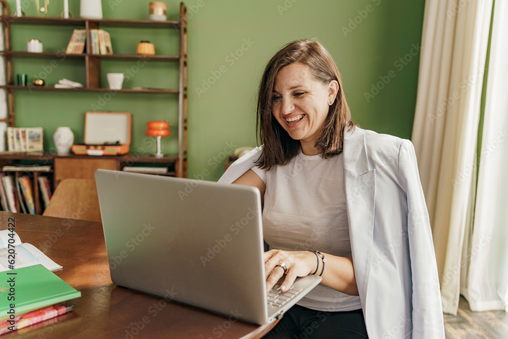 An architect is a female designer working online designing a new startup, using a laptop on a desk. A workplace in a stylish office. An architect is a female designer working online designing a new startup, using a laptop on a desk. A workplace in a stylish office.