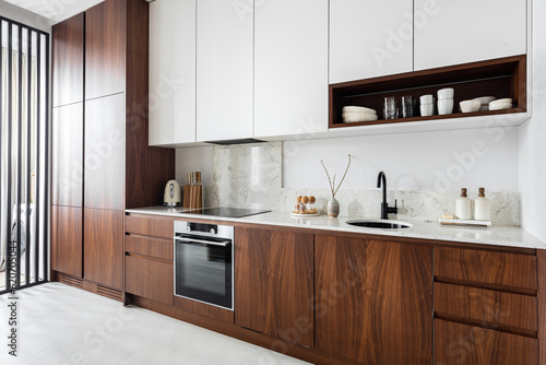 Modern kitchen with wood cabinetry covering fridge freezer dishwasher  photo