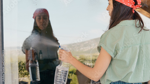 Woman washing a glass window outdoors photo