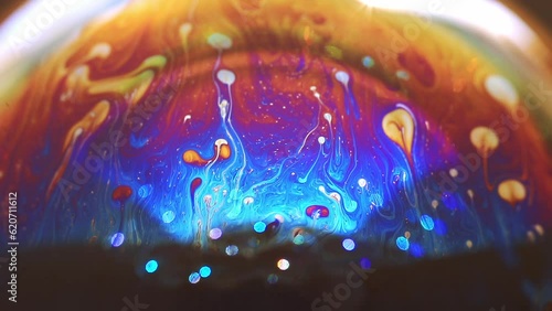 Abstract multicolored chaotic swirl texture inside of the soap bubble, closeup