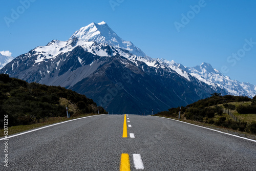 road leading to a snowcapped mountain photo