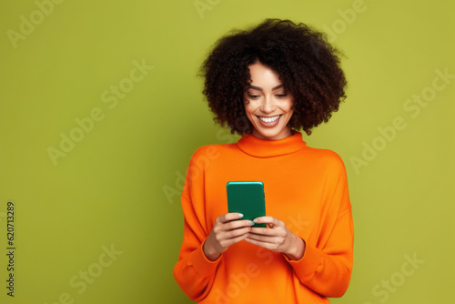 African American Woman with Phone, Orange Shirt, Green Backdrop