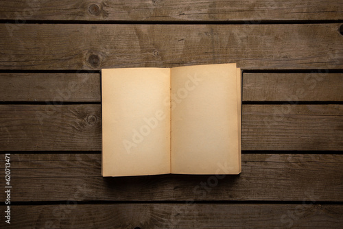 Vintage book, open, on old wooden table, with clipping path. Open Book blank on old wooden background. book with blank pages