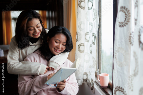 Grown up sisters spending happy leisurely time together indoors photo