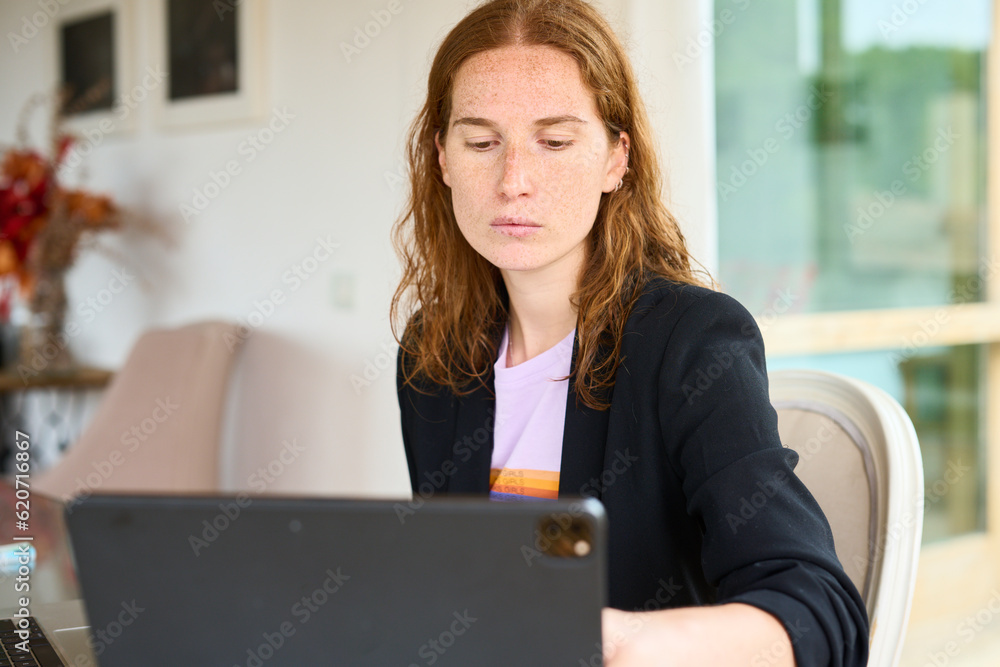 Focused woman browsing tablet in light office Focused woman browsing tablet in light office