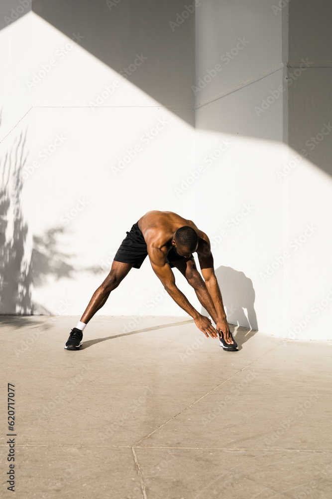 A muscular man does sports on the street A muscular man does sports on the street