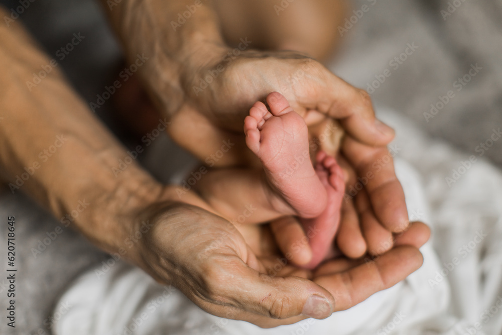 Fototapeta premium father holding his son's baby feet in his hands