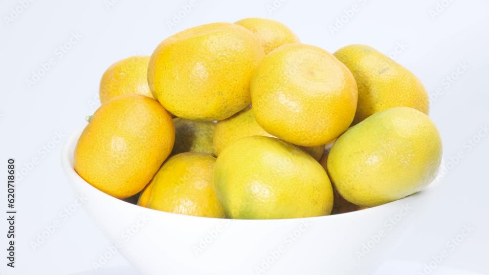 Fresh tangerines on white plate rotating in front of camera, Close-up rotates view of tangerines against the white background Fresh tangerines on white plate rotating in front of camera, Close-up rotates view of tangerines against the white background