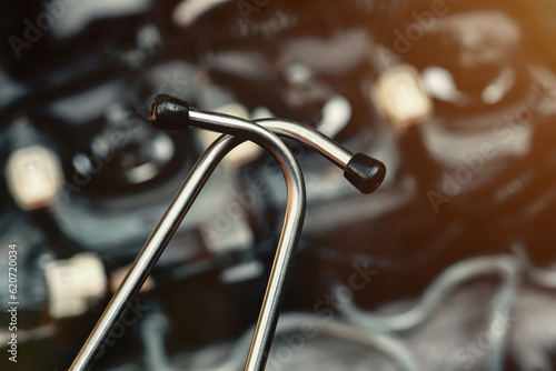 A car mechanic diagnoses car problems with a special stethoscope. Close-up. Car repair in a car repair shop