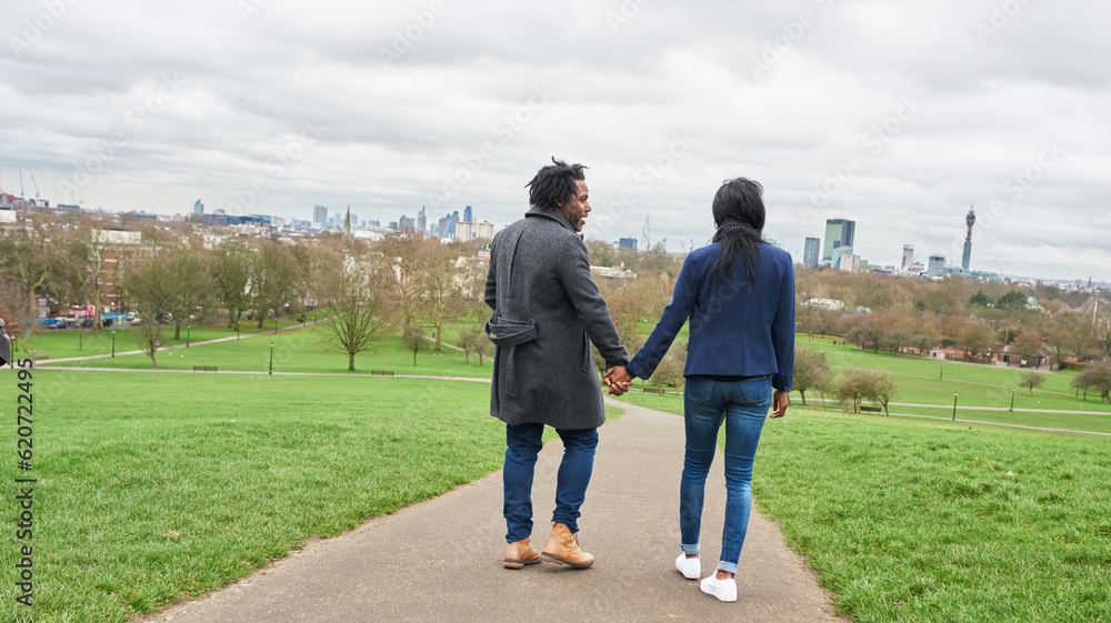Boyfriend and girlfriend walking hand in hand in park. Boyfriend and girlfriend walking hand in hand in park.
