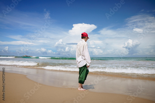 A woman walks by the ocean on a Sri Lankan beach photo