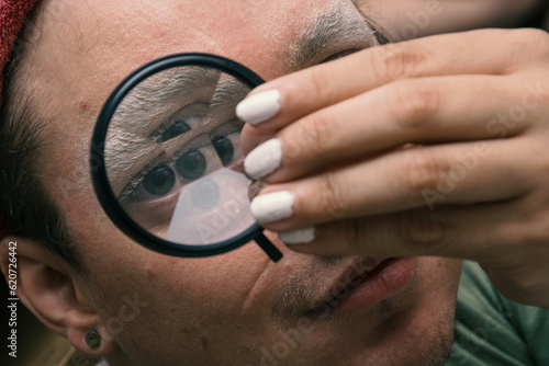 Man doing his make up with a caleidoscopic filter con his eye photo