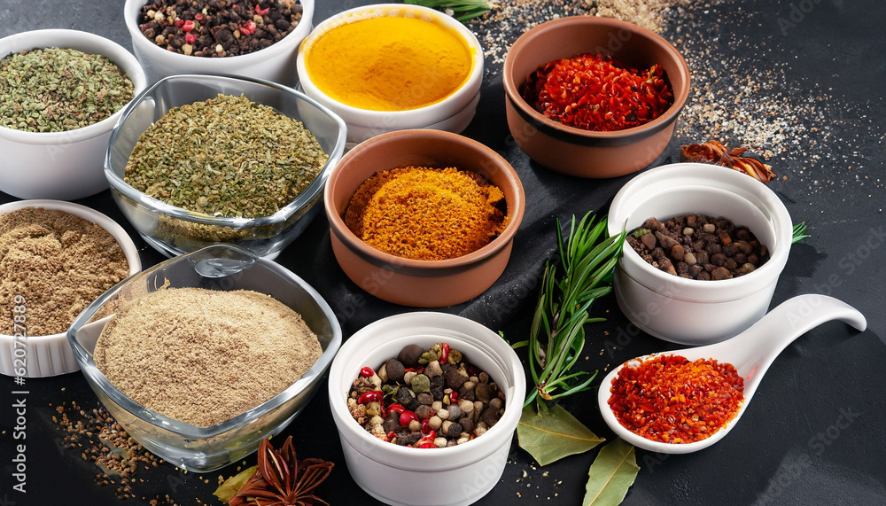 Colorful collection spices and herbs on background black table. Mediterranean condiments for decorating packing with food.