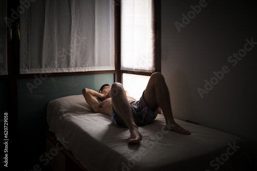 Lazy teenage man lying on bed photo