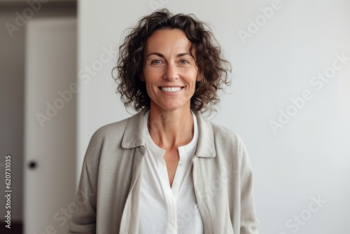 Obraz na płótnie Portrait of smiling mature businesswoman standing against white wall at office w salonie