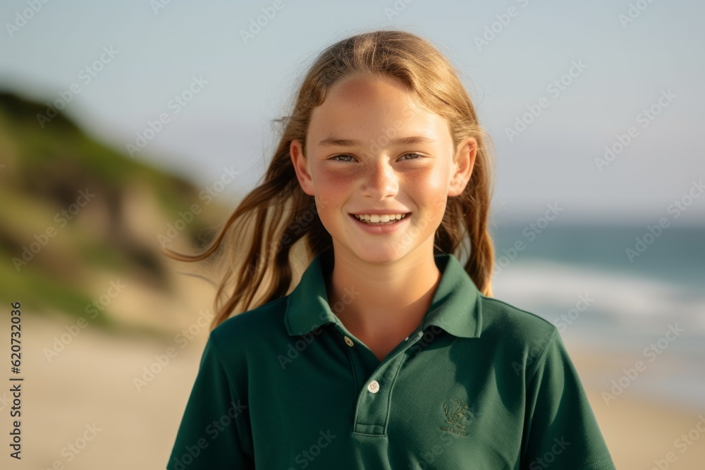 Portrait of a smiling young girl standing on the beach at sunset