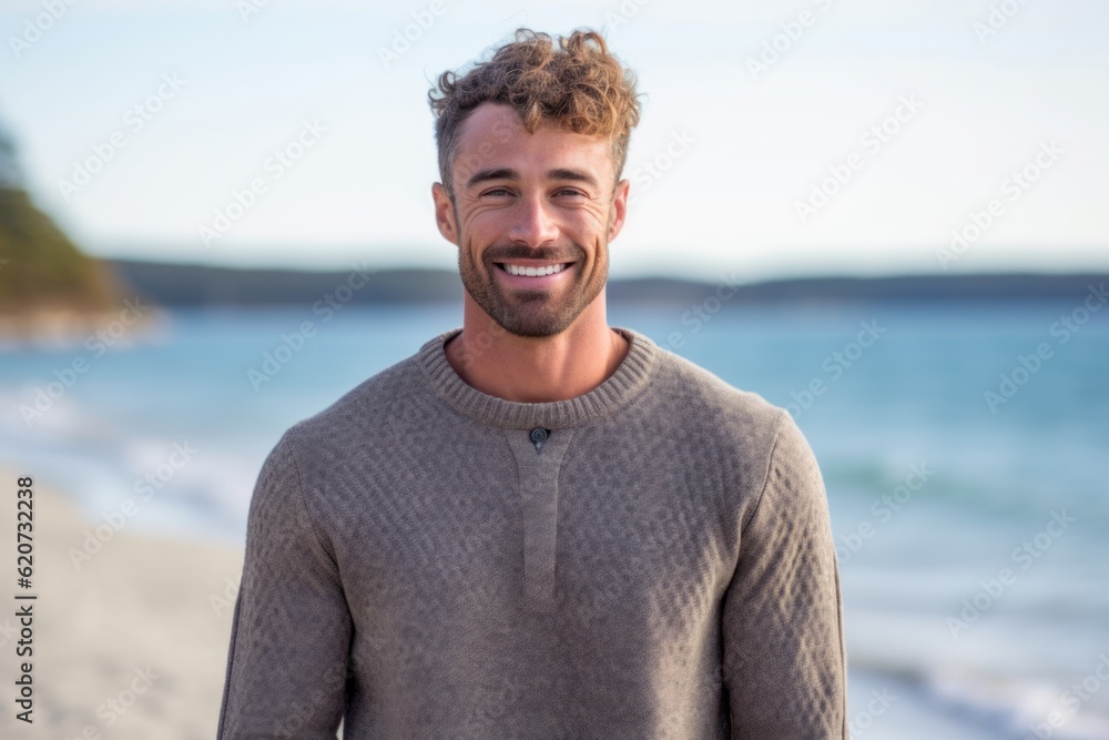 Lifestyle portrait photography of a satisfied man in his 30s wearing a cozy sweater against a beach background