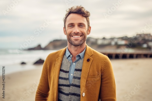 Portrait of handsome man standing on the beach and looking at camera
