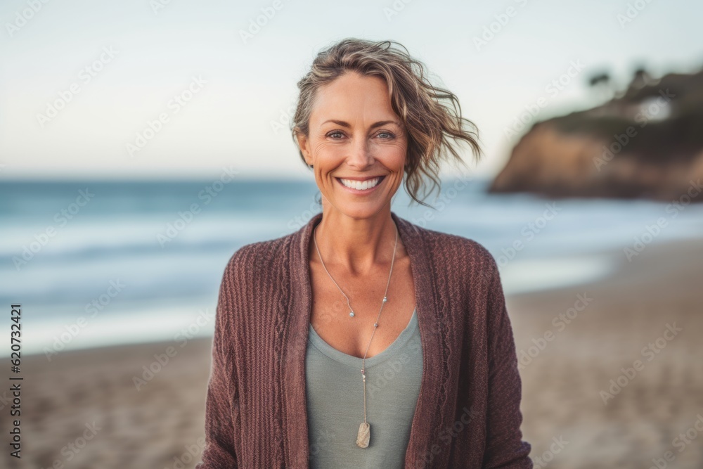 Portrait of smiling woman standing on beach at the day time and looking at camera Portrait of smiling woman standing on beach at the day time and looking at camera