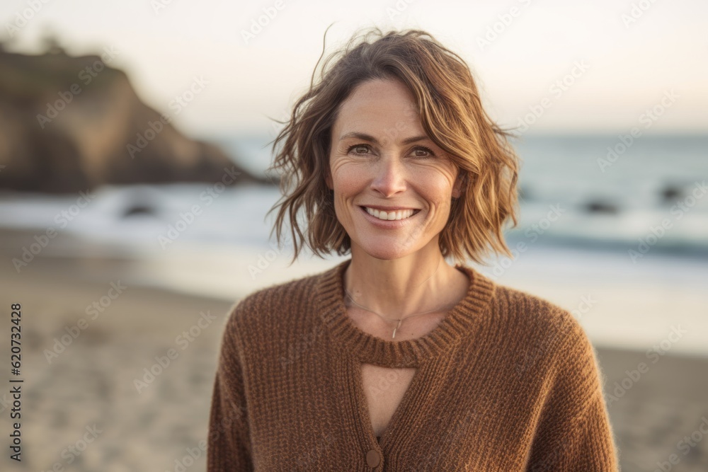 Portrait of smiling woman standing on beach at the day time with ocean in background Portrait of smiling woman standing on beach at the day time with ocean in background