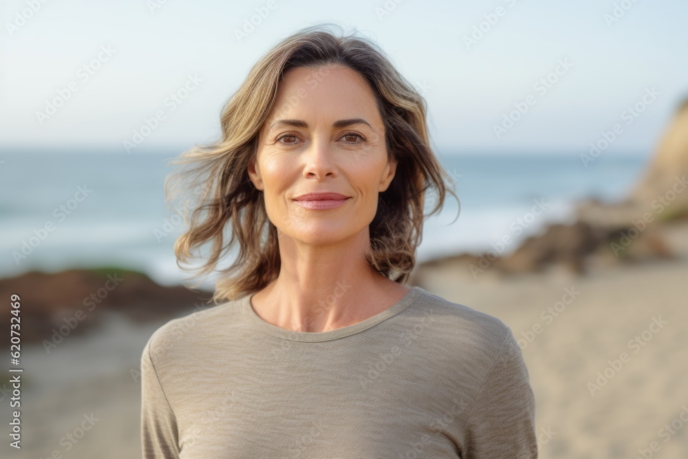 Portrait of a smiling woman standing on the beach at the day time Portrait of a smiling woman standing on the beach at the day time