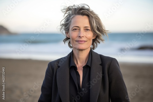 Portrait of smiling mature woman standing on the beach at the day time