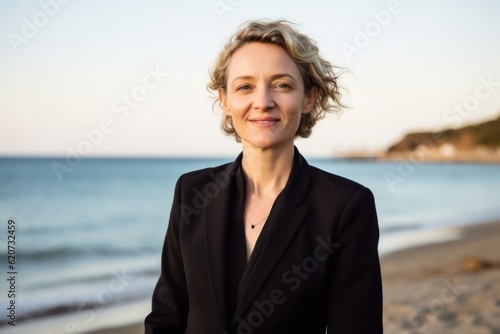 Portrait of a beautiful woman in a black suit on the beach