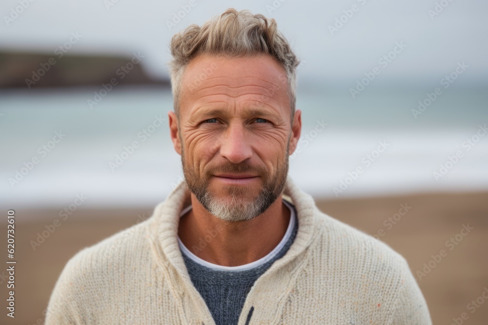 Portrait of handsome man looking at camera at beach on a sunny day Portrait of handsome man looking at camera at beach on a sunny day