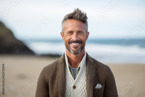 Portrait of smiling man standing on beach at the beach in autumn