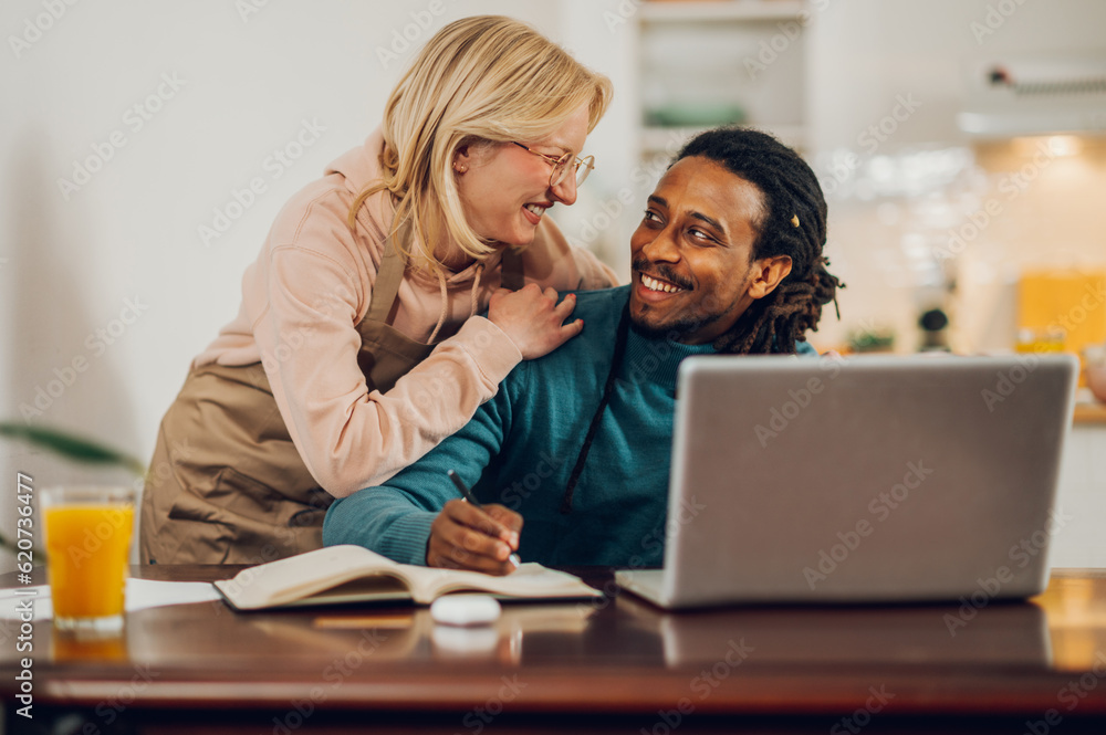 A happy interracial couple in love smiling at each other at home. A happy interracial couple in love smiling at each other at home.
