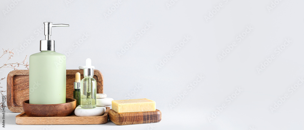 Fototapeta premium Bottle with liquid soap and essential oils on light background with space for text