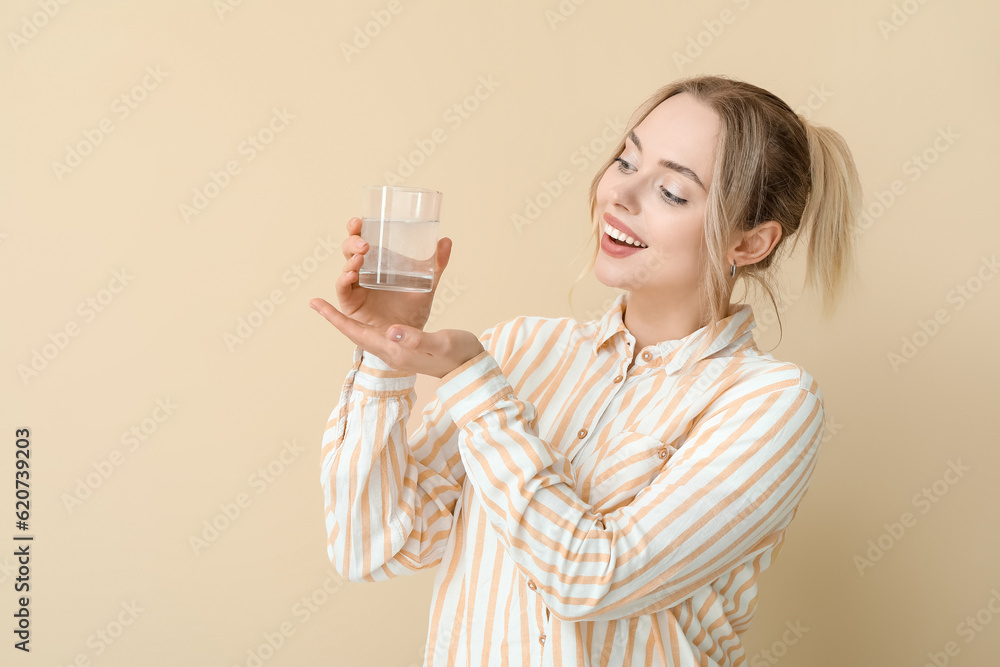Young woman with dissolved tablet in glass of water on beige background Young woman with dissolved tablet in glass of water on beige background