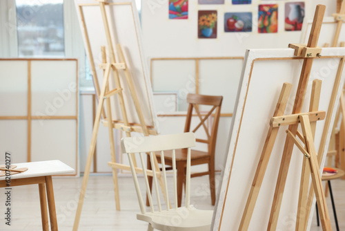 Stylish artist s studio interior with chairs in front of easels with canvases. Creative hobby