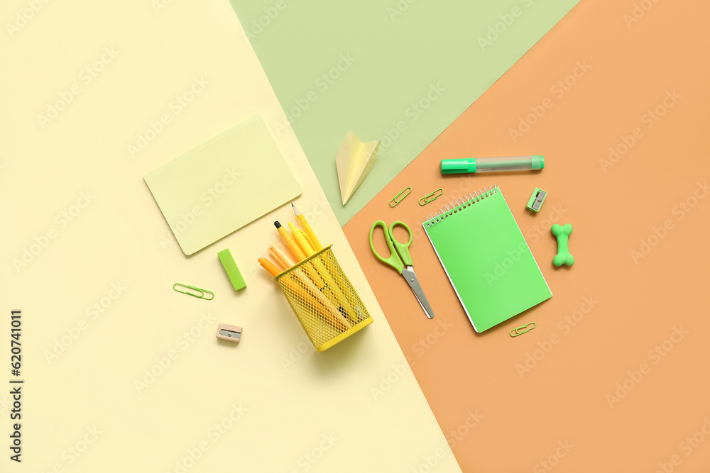 Composition with notebooks and different school stationery on color background Composition with notebooks and different school stationery on color background