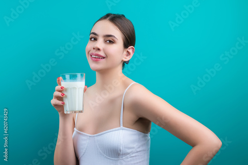 Woman drinking milk. Girl drinking milk , isolated on studio background. Young woman enjoy pure fresh milk. Thirsty woman hold glass milk. Healthy drinking.