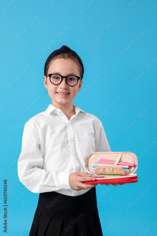 Little schoolgirl with pencil case on blue background Little schoolgirl with pencil case on blue background