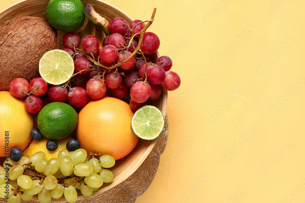 Bowl with different fresh fruits on orange background Bowl with different fresh fruits on orange background