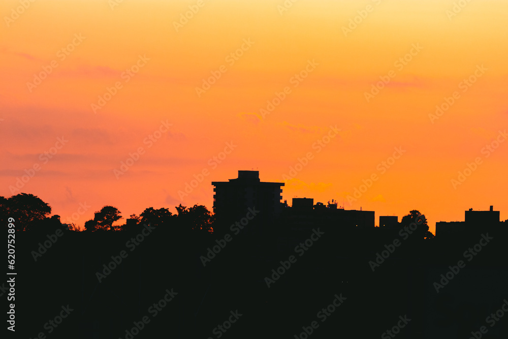 Sunset city silhouette with the orange sky above the buildings from puerto rico golden hour time 