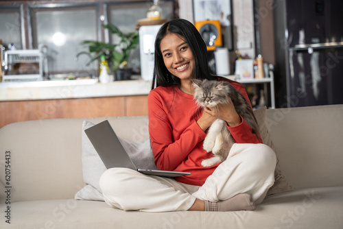 Beautiful asian Woman holding Persia cat in hand at home. Woman look happiness to stay and enjoy with her pet. Friendship, Love, Happiness, Lifestyle and Relaxation concept.