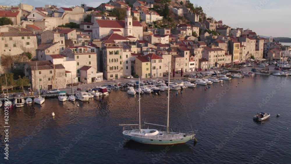 Sail boat anchored in harbour of Šibenik town during sunset, aerial Sail boat anchored in harbour of Šibenik town during sunset, aerial