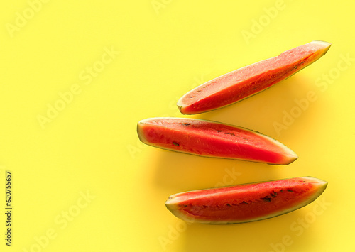 Pieces of fresh watermelon on yellow background