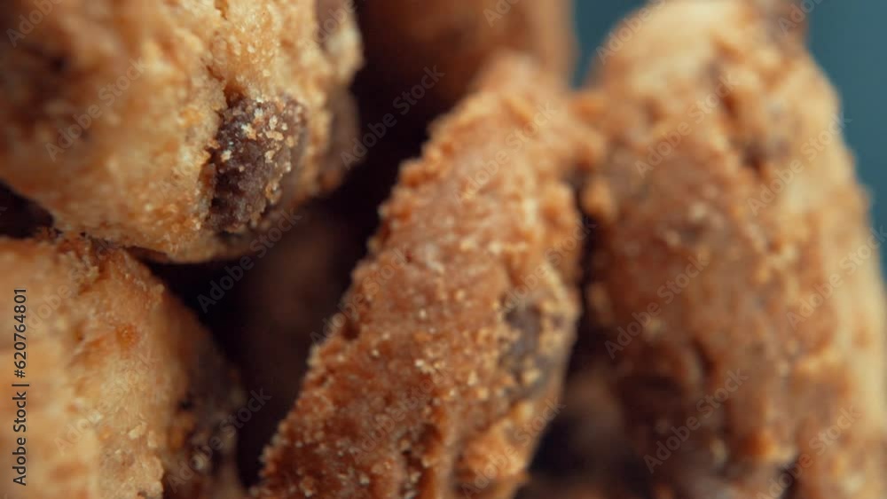 A vertical macro close up cinematic shot of a plate full of crispy chocolate chip cookies, on a rotating stand, studio lighting, super slow motion, 120 fps, Full HD video A vertical macro close up cinematic shot of a plate full of crispy chocolate chip cookies, on a rotating stand, studio lighting, super slow motion, 120 fps, Full HD video